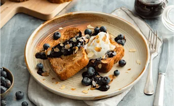 Wentelteefjes van suikerbrood met blauwe bessensaus