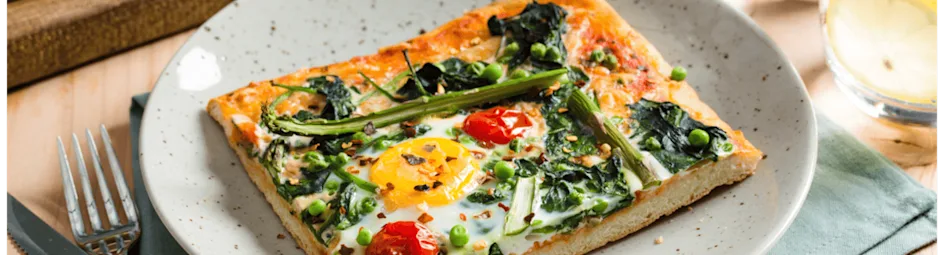 Plaatpizza met groene groenten en een eitje