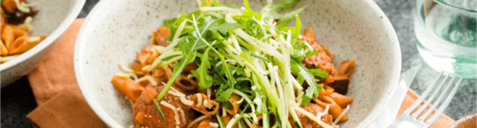 Volkorenpasta met balletjes in tomatensaus en een groene salade