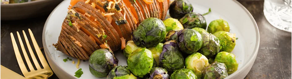 Hasselback zoete aardappel met gerookte zalm en regenboog spruiten