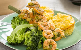Aardappelgratin met gestoomde broccoli en garnalenspiesen