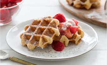 Gesuikerde wafels met hangop en aardbeien