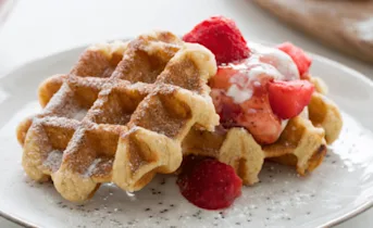 Gesuikerde wafels met hangop en aardbeien