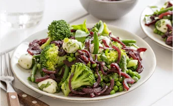 Knapperige groene salade van peulvruchten met een uiencompote