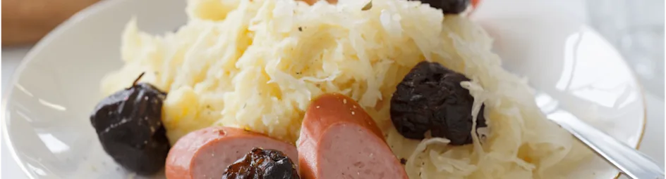 Zuurkoolstamppot met gegrilde pruimen en worst