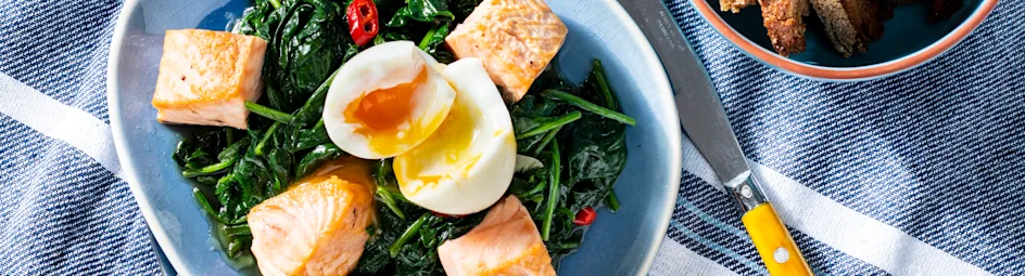 Gebakken spinazie met ei, krokante zalmchunks en knoflookcroutons
