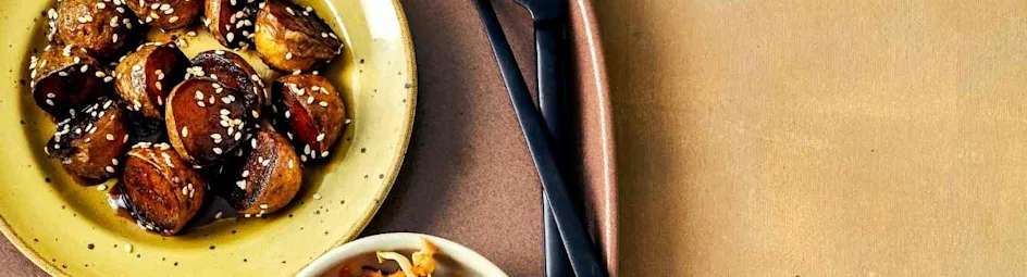 Geglaceerde sesamaardappeltjes met wortel-koolsalade en kip