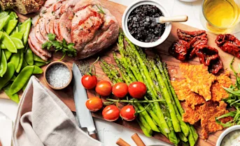 Gebraden beenham, uiencompote, groene asperges en parmezaankoekjes