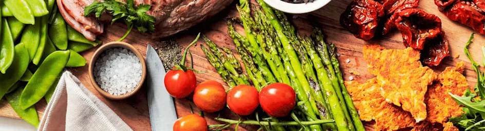 Gebraden beenham, uiencompote, groene asperges en parmezaankoekjes