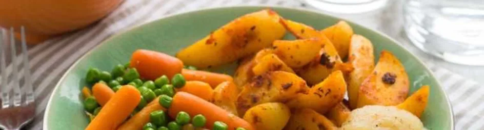 Kabeljauwfilet met doperwten, wortelen en gekruide aardappelpartjes
