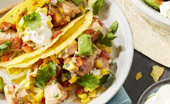 Taco shells gevuld met een ceviche van gemarineerde zalmfilet en groente