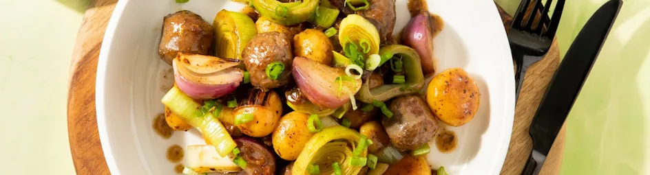 Eenpansschotel van krieltjes, prei, rode ui en rundersaucijs met rozijntjes