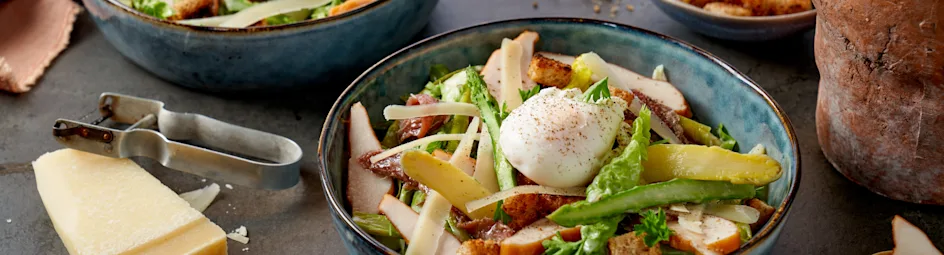 Caesar Salad van witte en groene asperges met gepocheerde eitjes