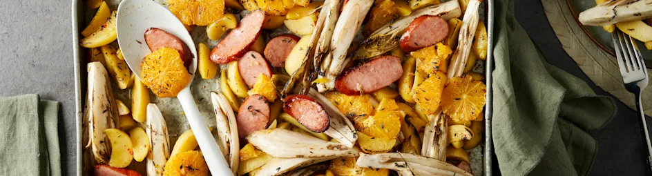 Traybake van witlof, kiprookworst en sinaasappel met knoflookaardappeltjes