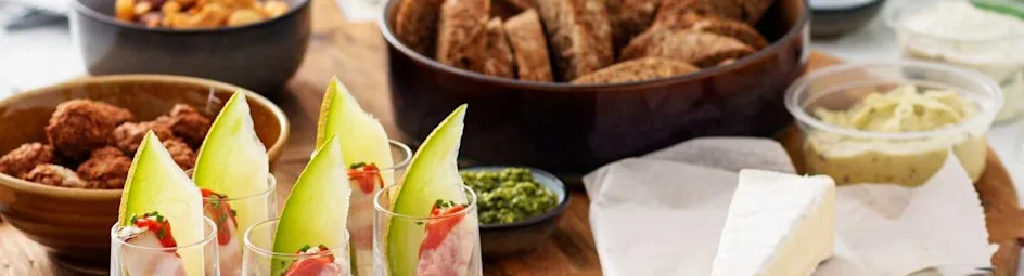 Meloen en Serrano-roomkaasrolletjes in shotglaasjes met hot sauce