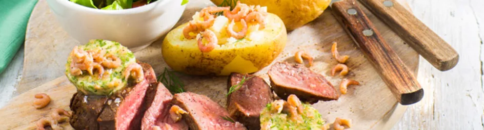 Biefstuk met garnalen-dilleboter met pofaardappel en sla