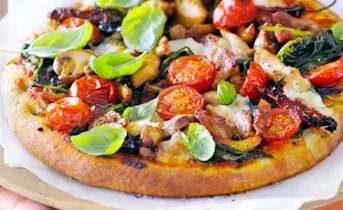 Pizza met kip, verse spinazie en verse cherrytomaten