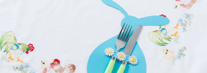 Blauwe bestekhouder in de vorm van een konijn, gemaakt van papier.