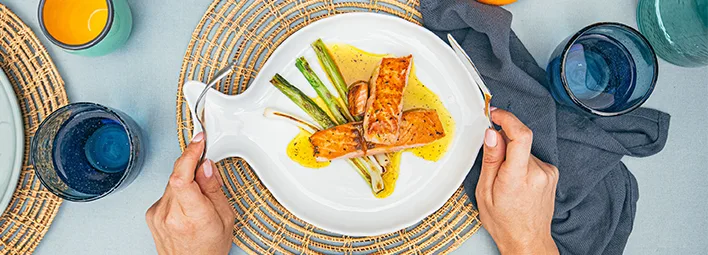 Duurzame zalm recept van gegrilde zalmfilets met groene asperges en een romige gele saus.