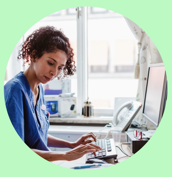 A nurse typing notes into a computer