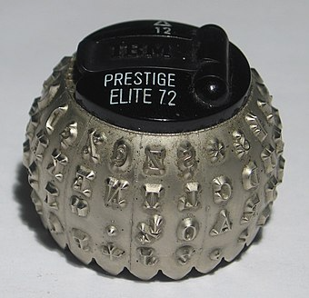 ALT text: A golf ball shaped IBM Slectric typing element with various characters in the chosen font.