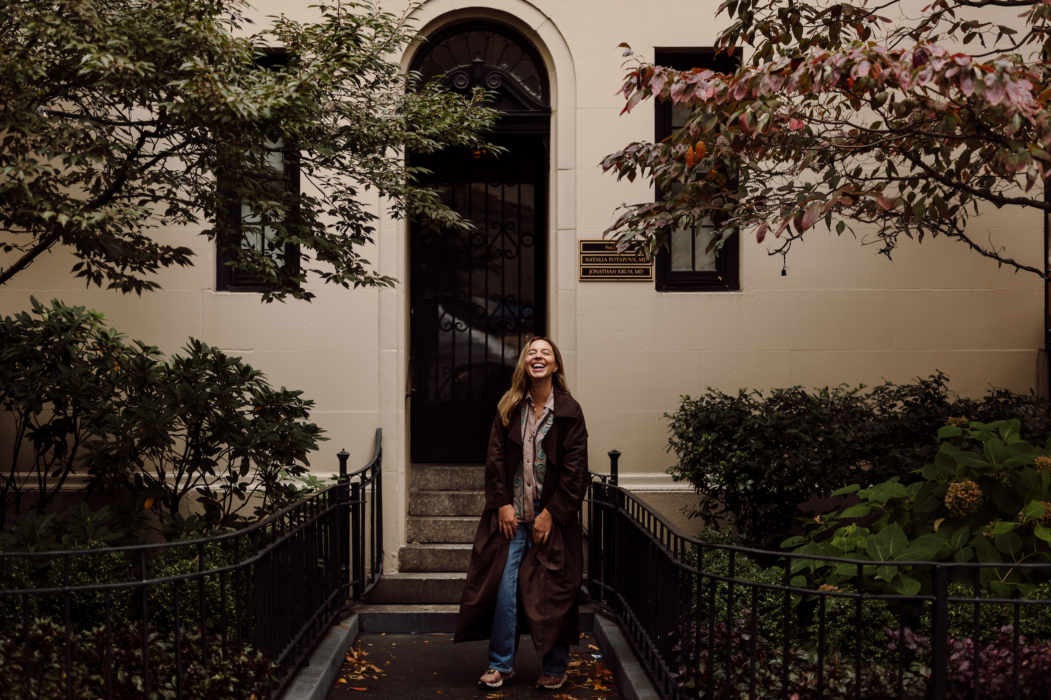Author Jana standing and laughing in a courtyard
