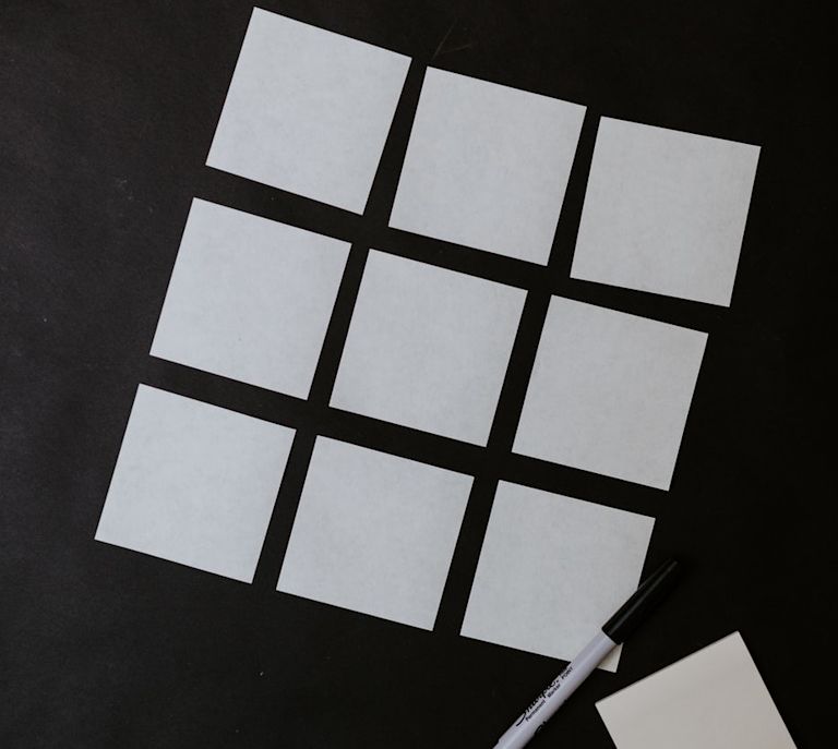Grid of white sticky notes on a black background