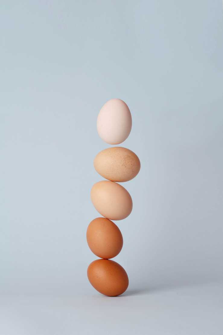 Five eggs are stacked precariously on top of each other.