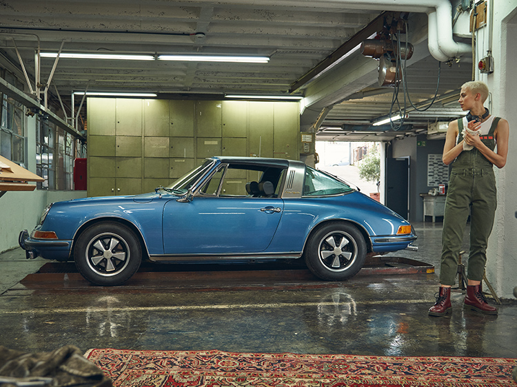 Woman with classic Porsche 911 Targa in a workshop