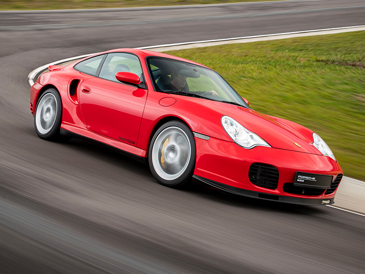 Red Porsche 911 Turbo speeding around bend of racetrack