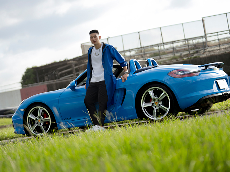 Jeremy Lin leans against Riviera Blue Porsche 718 Boxster GTS