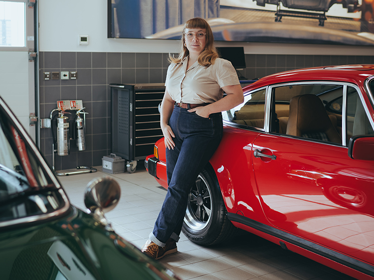 Woman standing next to a red classic Porsche 911