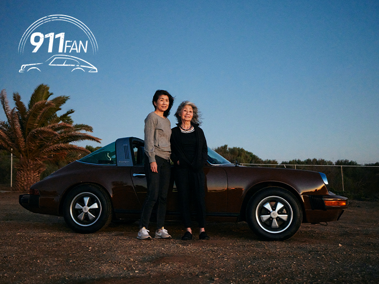 Two women with classic brown Porsche 911 Targa at dusk