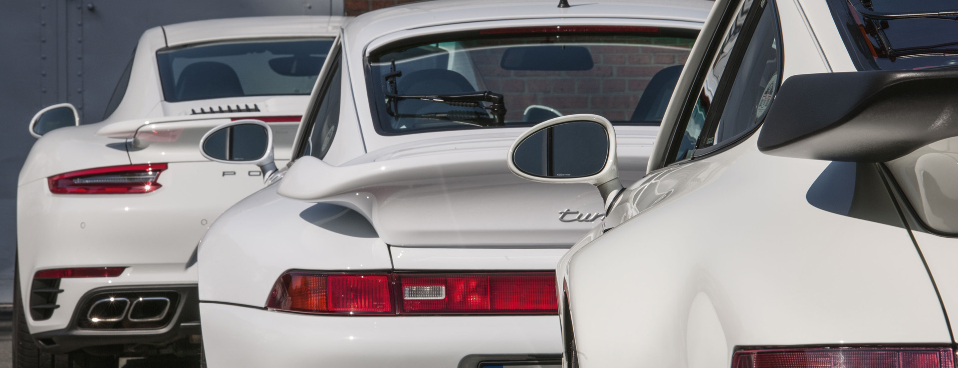 View of line of Porsche 911 sportscars and rear wings