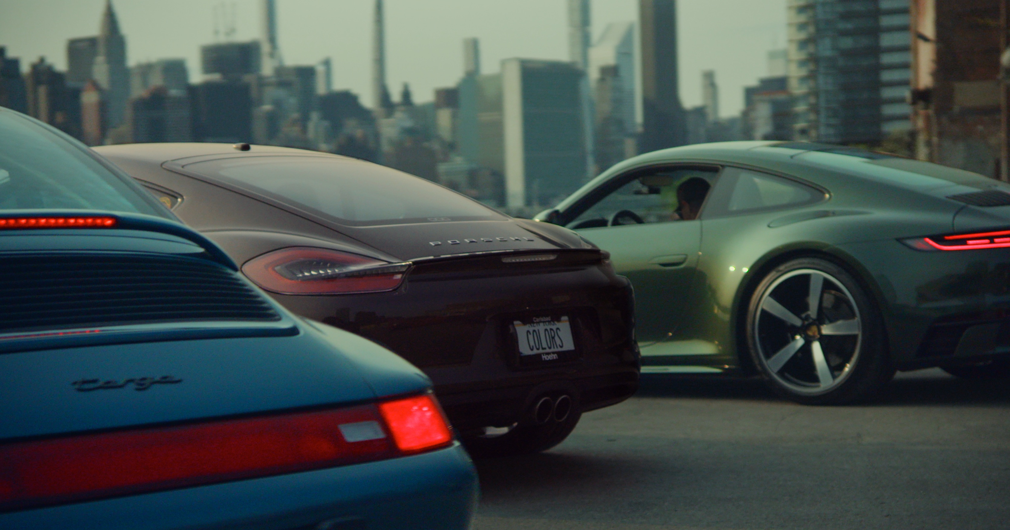 Line of colourful Porsche cars, Manhattan skyline as backdrop