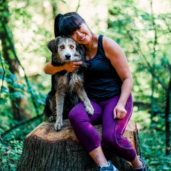 Woman hugging dog in the forest