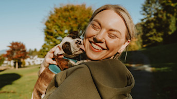 Pitbull puppy licking blonde woman's face