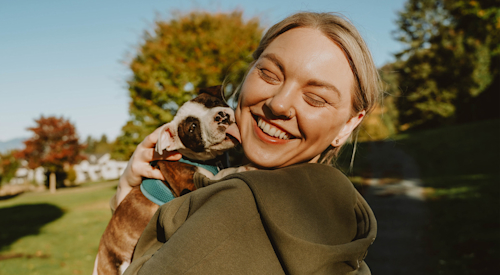 Pitbull puppy licking blonde woman's face
