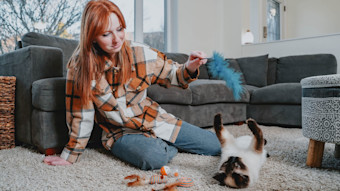 Red haired girl playing with cat