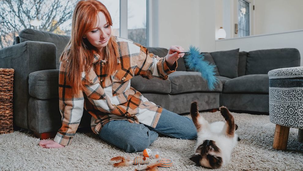 Red haired girl playing with cat