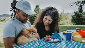 Pomeranian at picnic table with owners