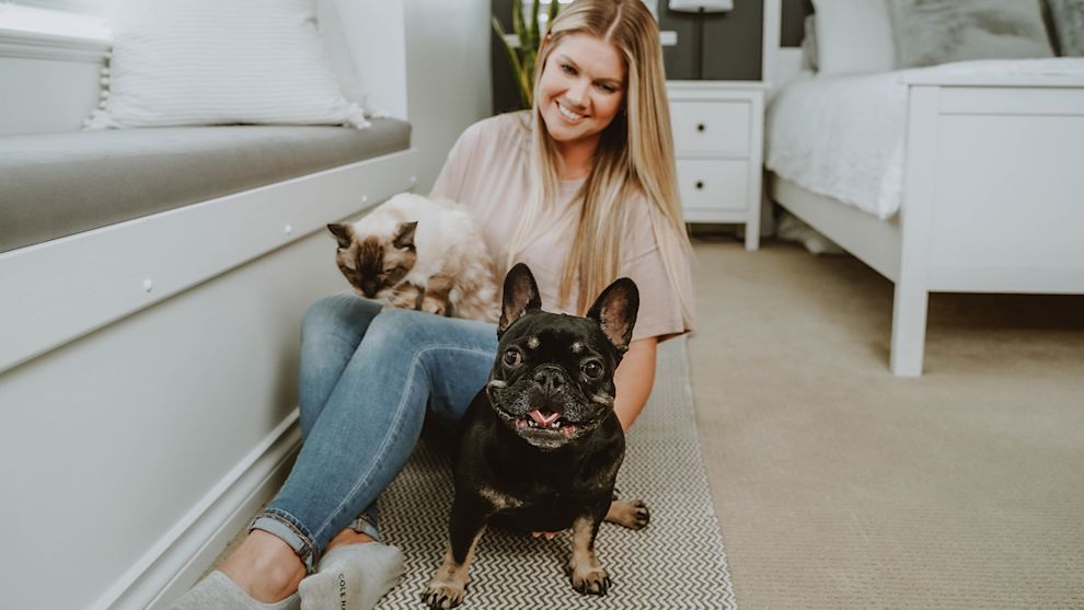 Woman in bedroom with cat and French Bulldog