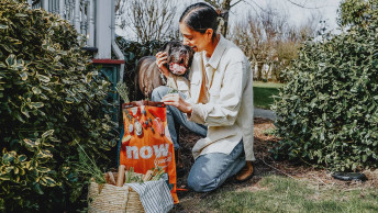 Pet parent and dog outdoors in garden with bag of Now Fresh 