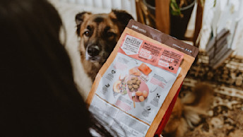 Owner reading the back of dog food bag