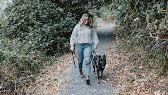 Black dog going for a walk with pet parent in leafy area