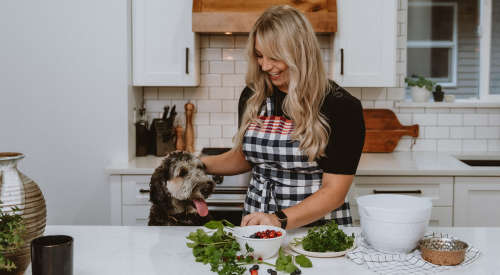 Woman cooking with dog in the kitchen