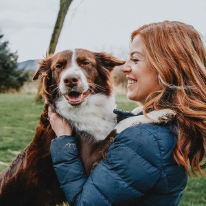 Red haired woman with dog in field