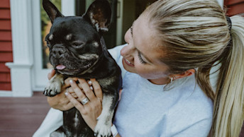 Blonde woman holding French Bulldog
