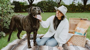 Woman and Chocolate Lab dog having a picnice