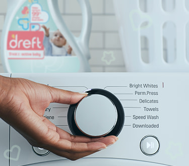 A washing machine with Dreft laundry detergent used to remove stains from children's clothes on it.